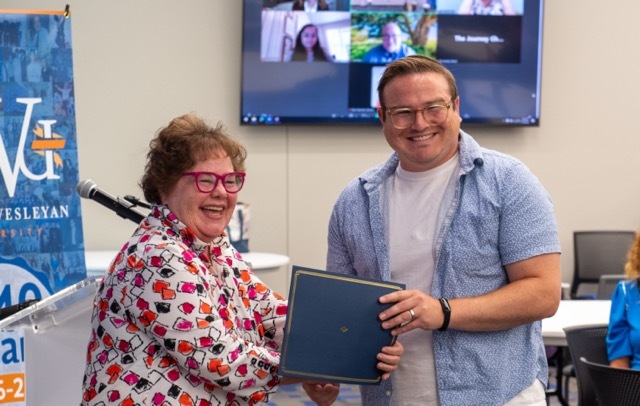 Two people smiling with certificate