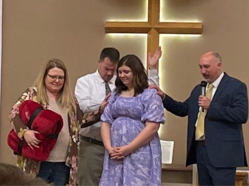 people praying over woman