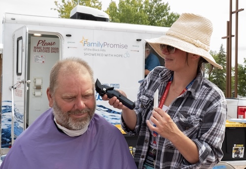 Woman trims man's hair