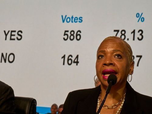 woman at microphone before vote tally