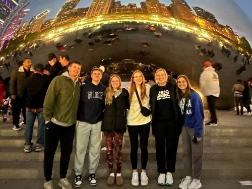 group posing by sculpture