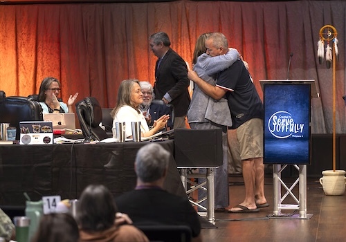 Two people hugging at podium